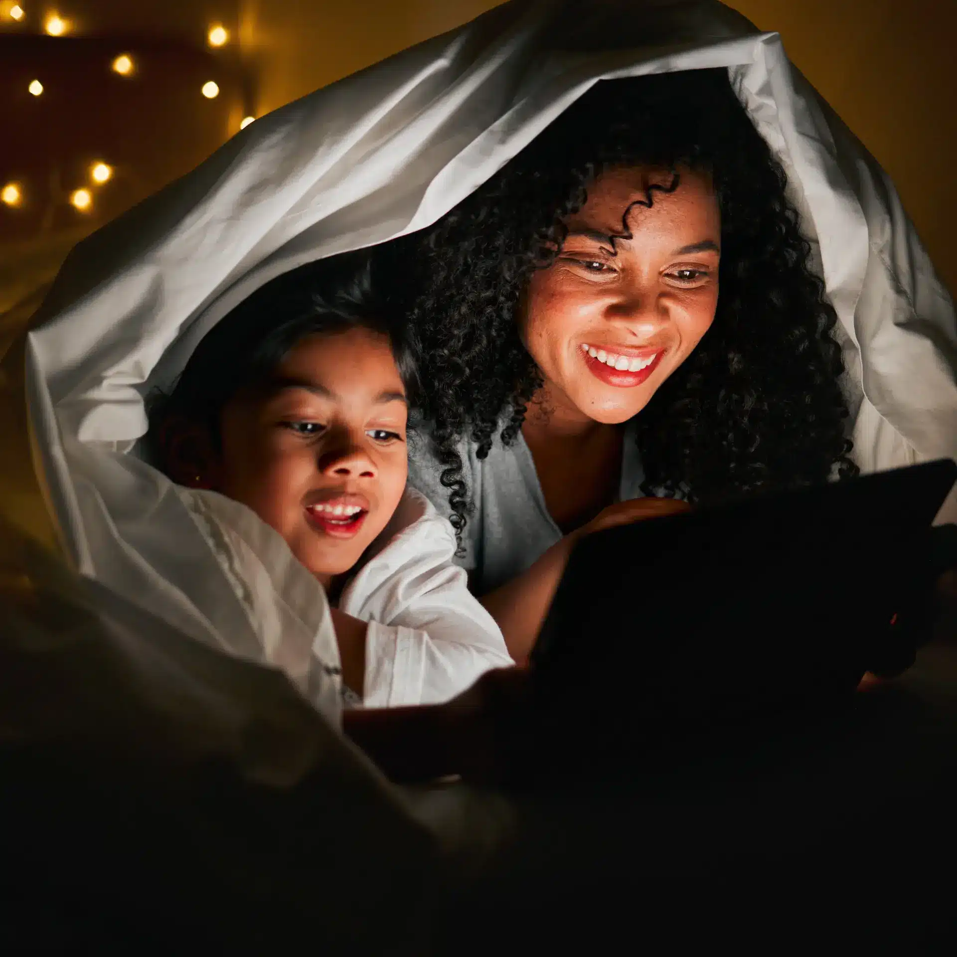mom and daughter under blanket reading after storm